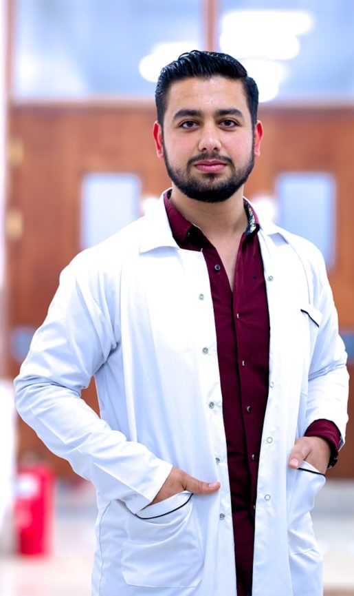a man in a lab coat standing with his hands on his hips